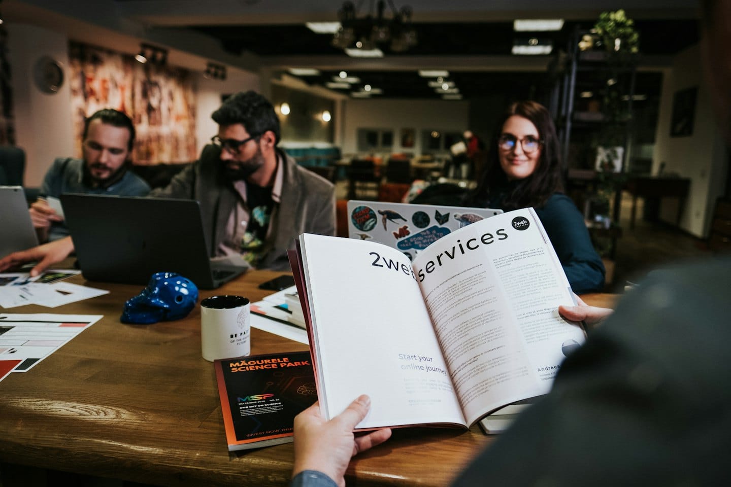 Des professionnels collaborant autour d'une table avec une brochure.