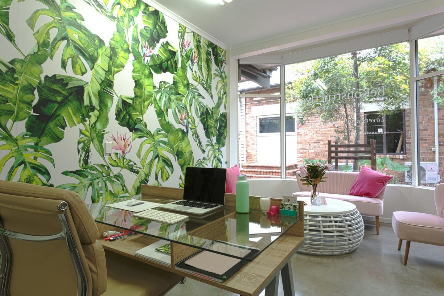 Bureau moderne avec un bureau en bois et une fresque murale florale.